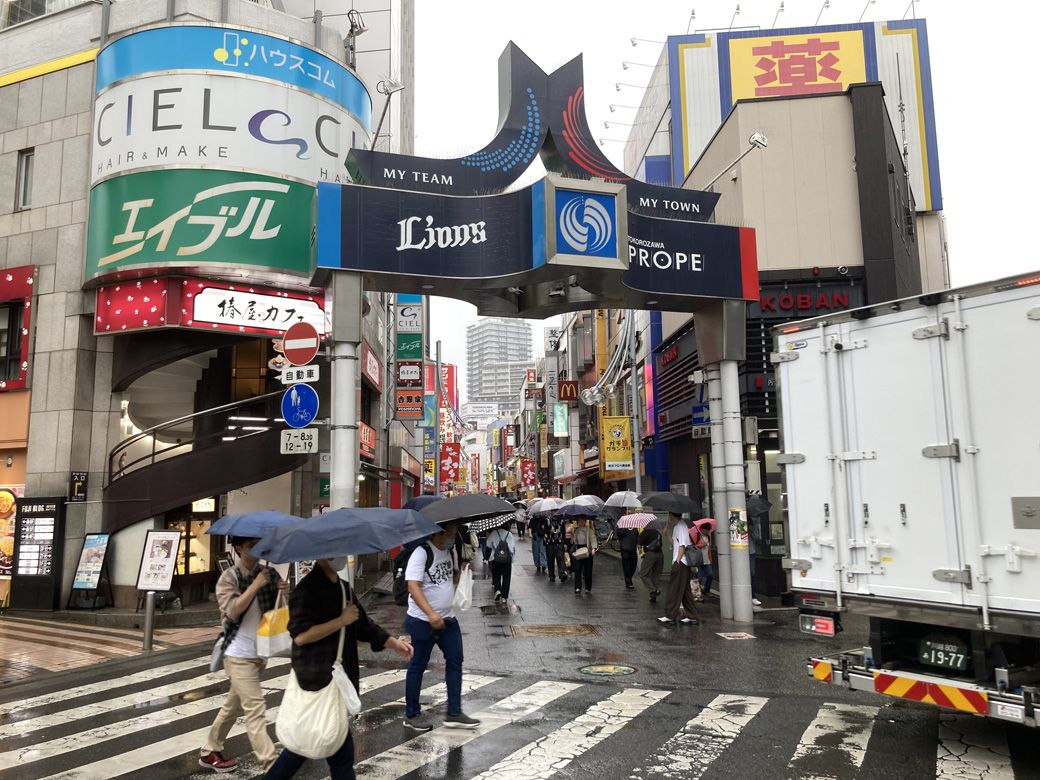 駅前から伸びるプロぺ通り。名前の由来が航空機で、ライオンズのロゴがあると考えると、看板に街の歴史が詰まっている（筆者撮影）