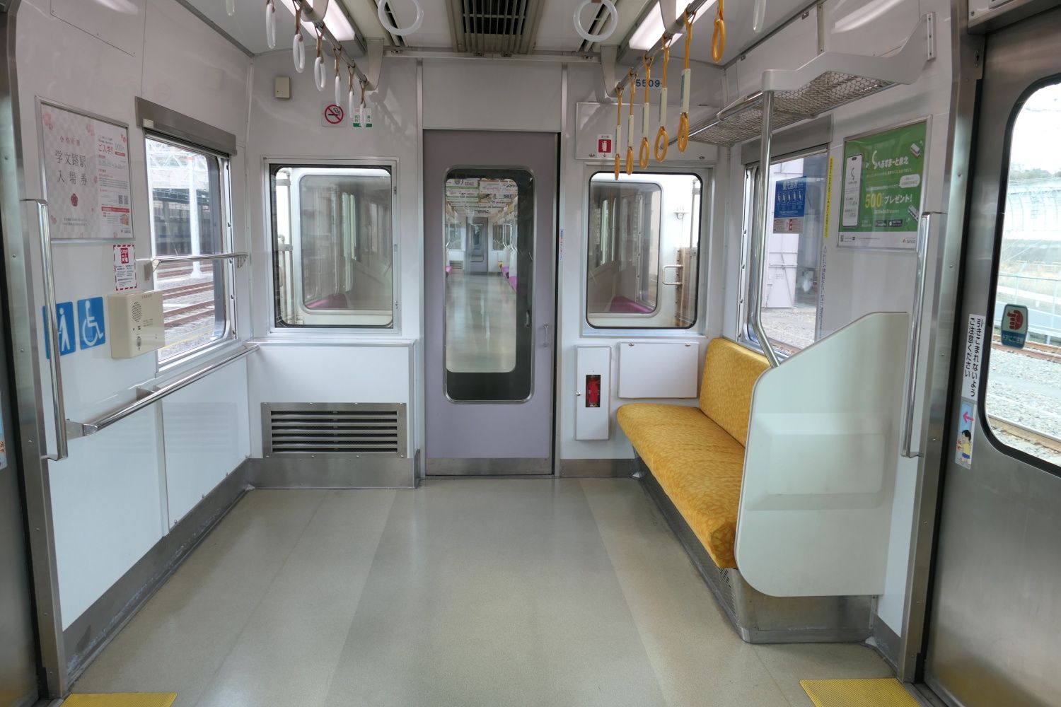 車端部の車いす・ベビーカー用スペースと優先座席（記者撮影）