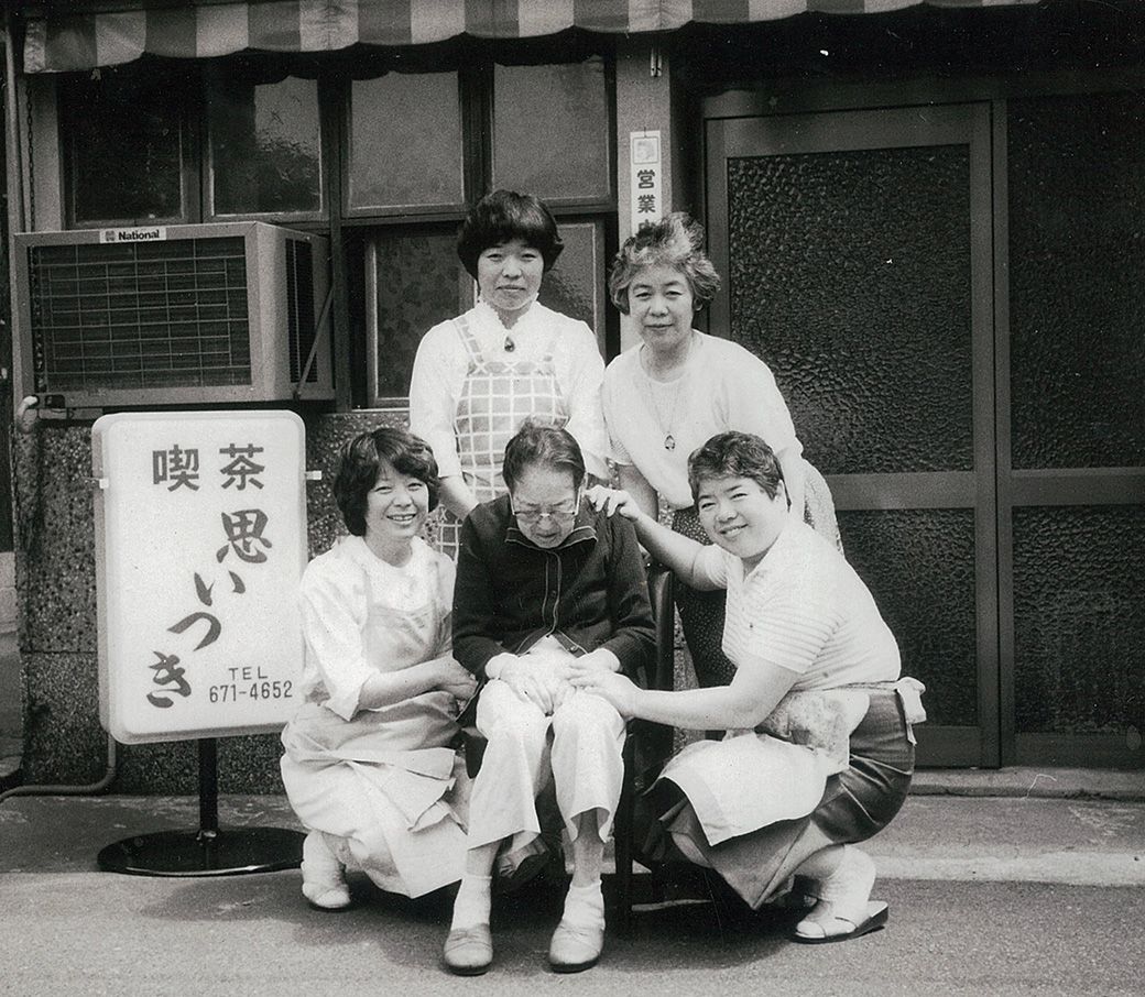 1986（昭和61）年、店の前で母・なみ江さんを囲む四姉妹（撮影：神戸船渠工業株式会社）