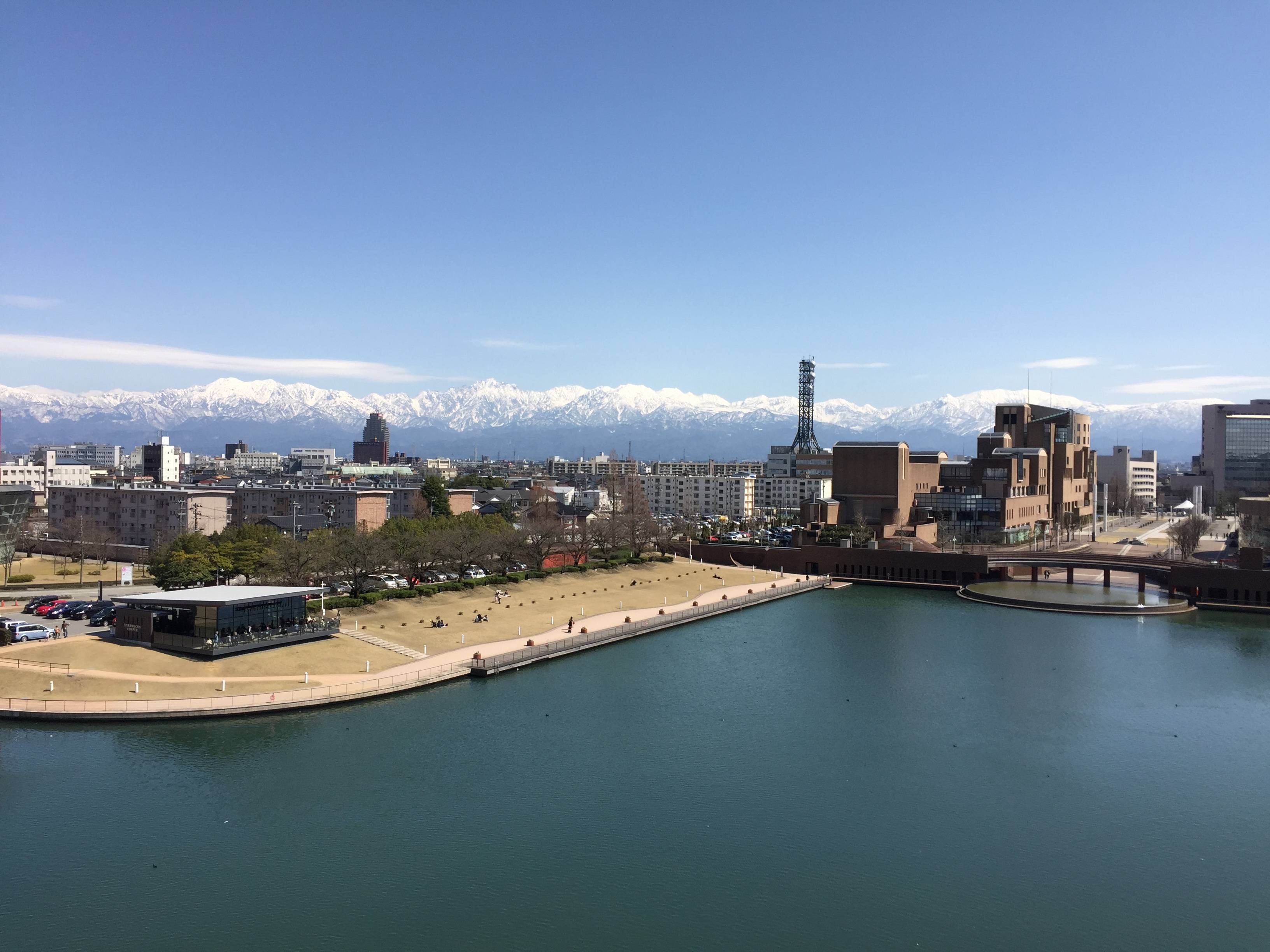 「富岩運河環水公園」の背景にそびえる立山連峰の山々（写真提供：富山県ロケーションオフィス）