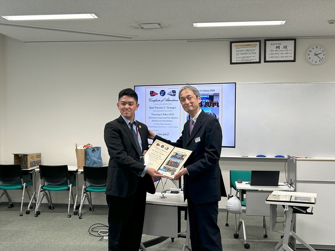 東京メトロの牛田氏（右）から研修の修了証を受け取るカール君（写真：東京地下鉄）