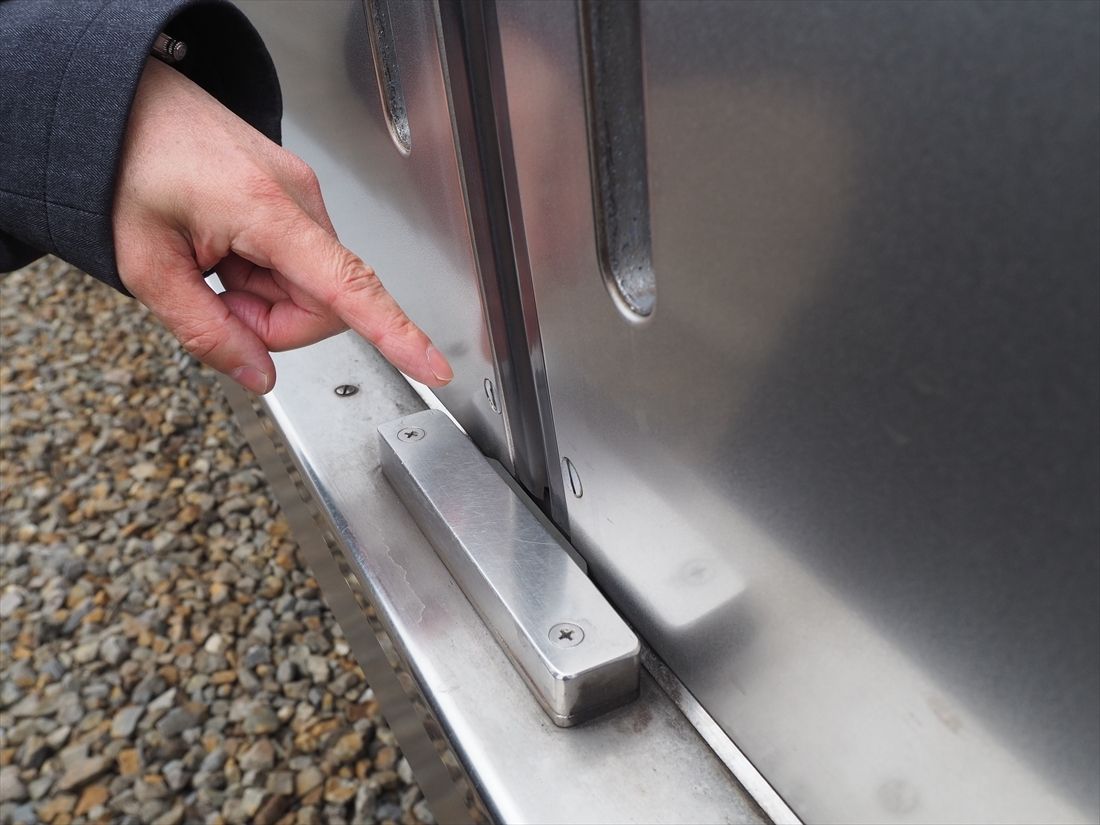 2000形の3編成目以降の車両は、走行中にドアのバタつきを抑える「音止め」を取り付けてより静かになった。指さしているグレーの部品（記者撮影）