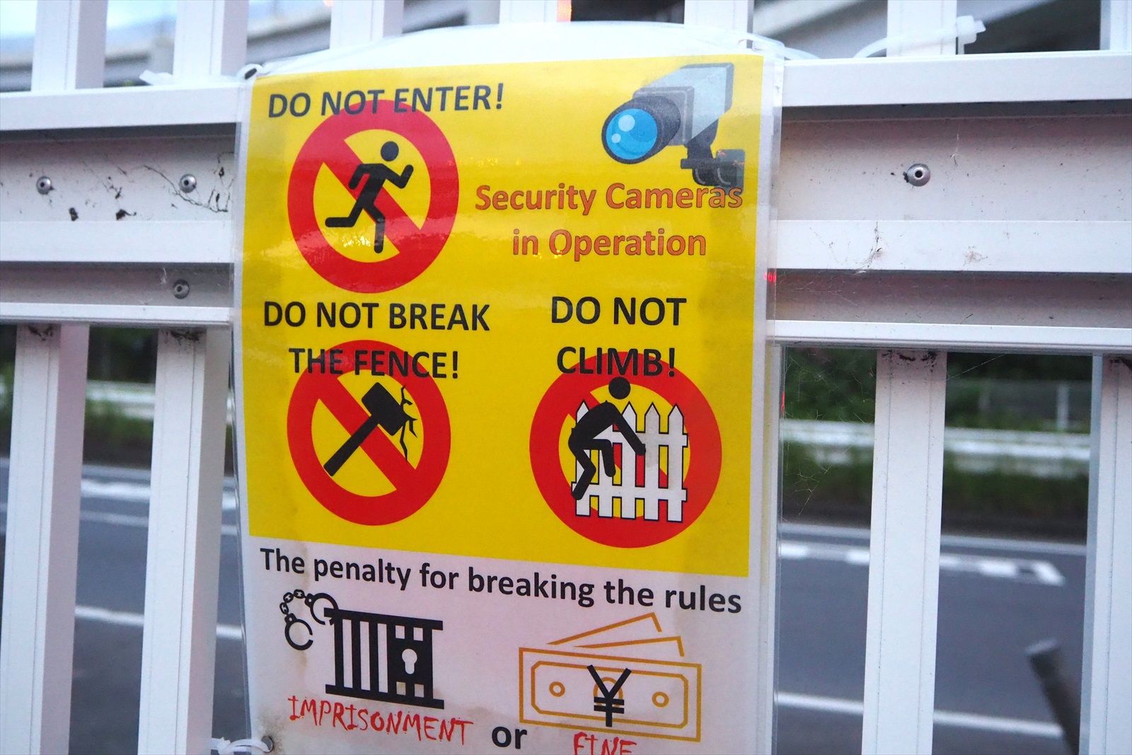 フェンスの乗り越え禁止を呼び掛ける標識（筆者撮影）