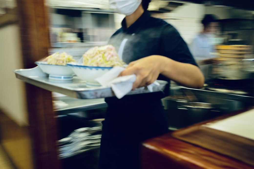 もくもくと湯気を立てながら運ばれていくどんぶりたちを、思わず目で追ってしまう（筆者撮影）