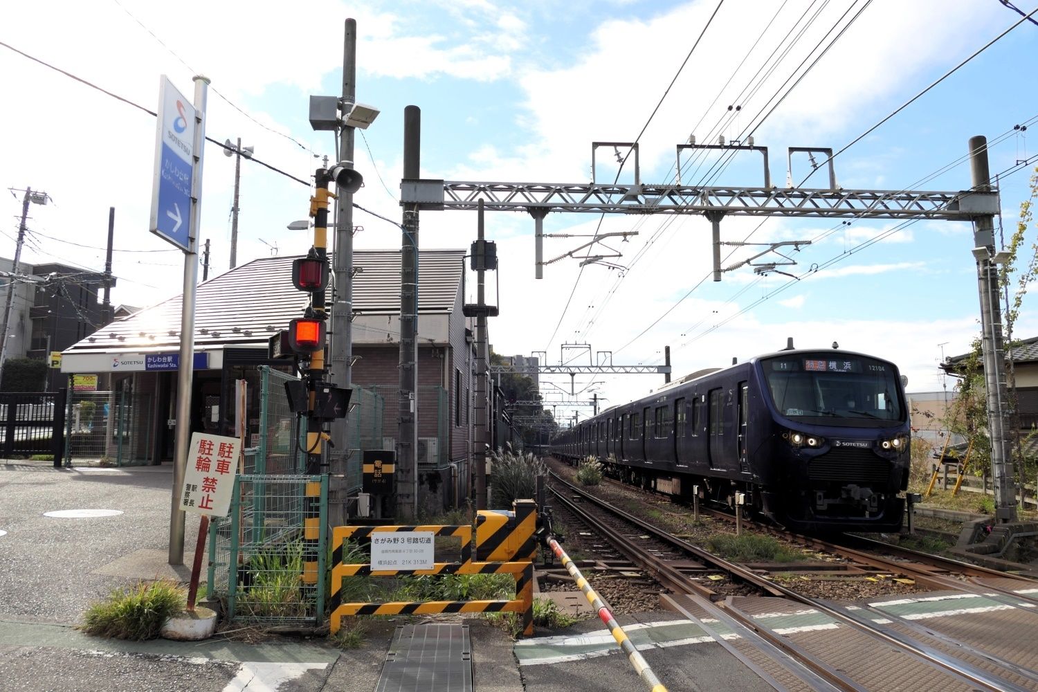 東口駅舎の横を走り抜ける電車（記者撮影）