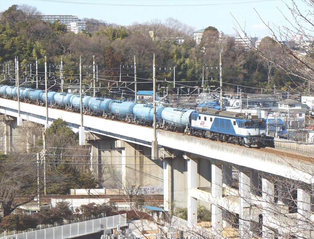 武蔵野南線の稲城付近、京王相模原線をまたぐ高架を行くEF64形1000番台牽引の貨物列車（撮影：南正時）