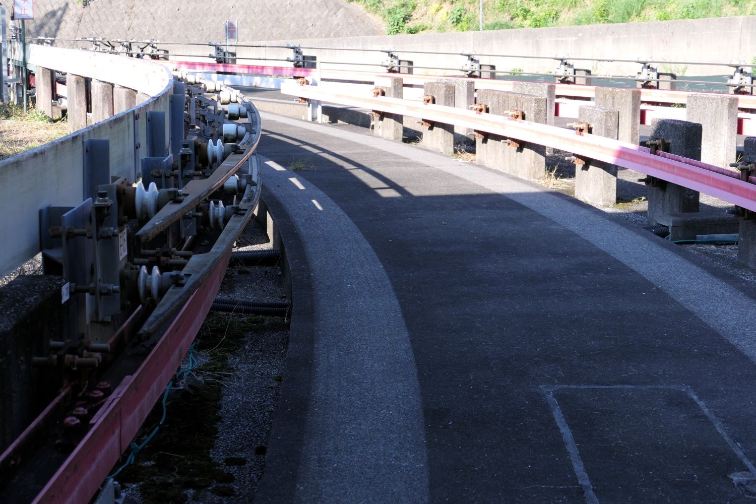 車両が走る走行路。左側面に上下に並んでいるのが架線、赤い部分が案内レール（記者撮影）