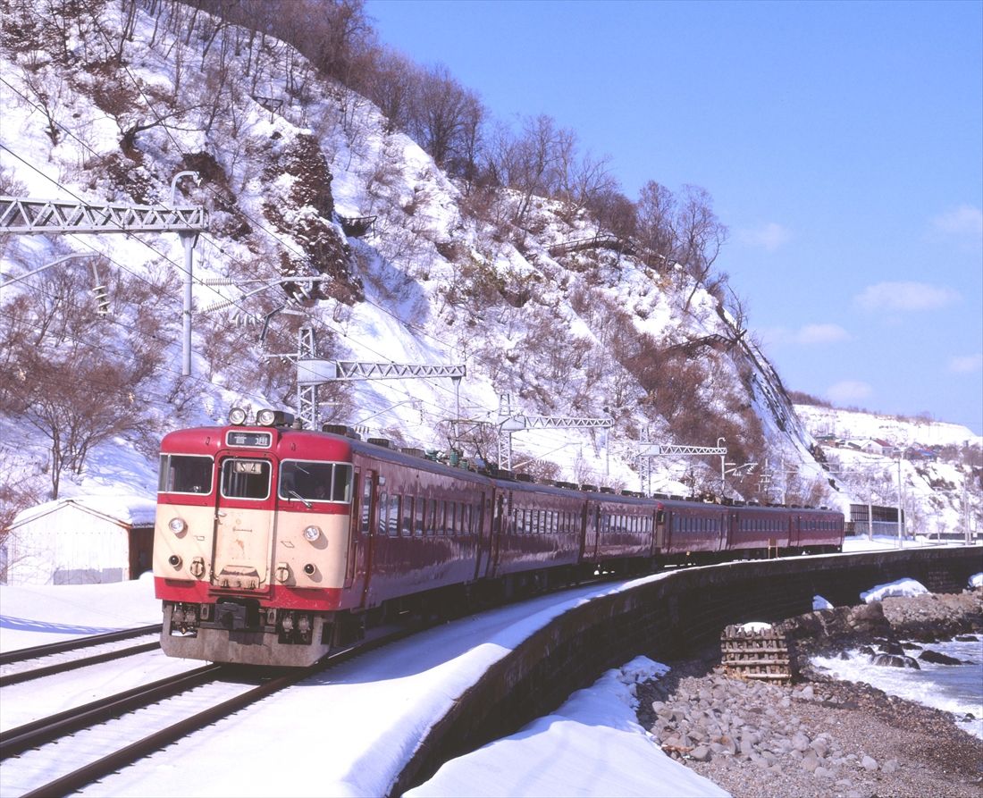 新雪の張碓海岸を行く国鉄時代の711系（撮影：南正時）