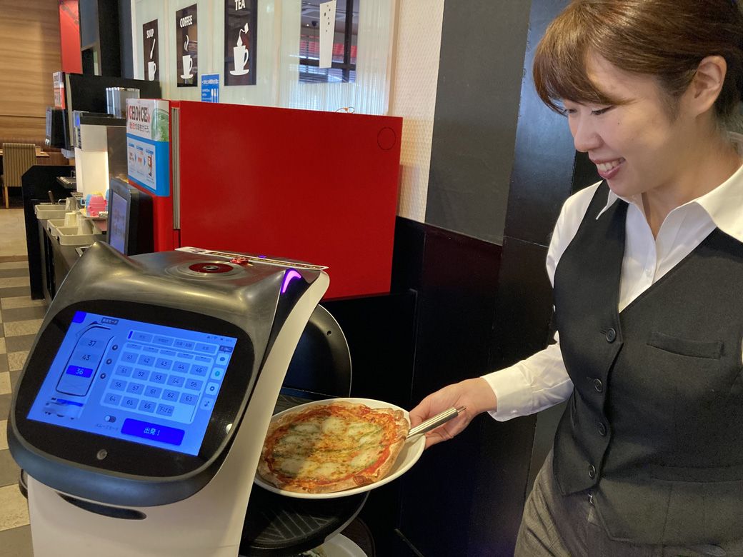 「ありがとね」など、猫型ロボットに話しかけるスタッフも（写真提供：すかいらーくホールディングス）