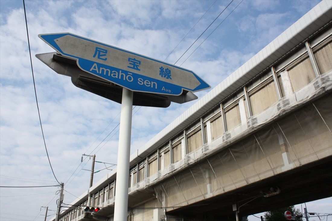 山陽新幹線の高架橋をくぐる。道路脇には県道42号の通称「尼宝線」の名を刻む案内標識が立っていた（筆者撮影）