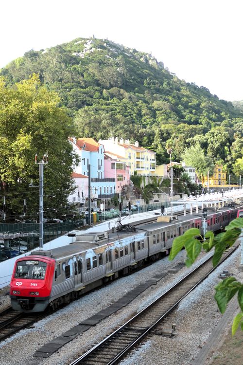 山の上の古城をバックに走る近郊電車（筆者撮影）