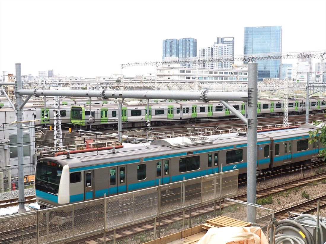 東京総合車両センターの横を通過する京浜東北線の電車（記者撮影）