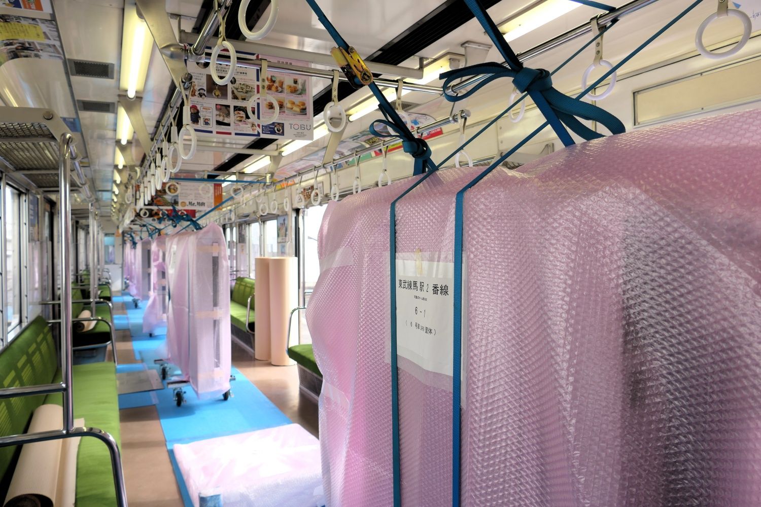 ロングシートの間にホームドアの筐体が並ぶ見慣れない光景（記者撮影）