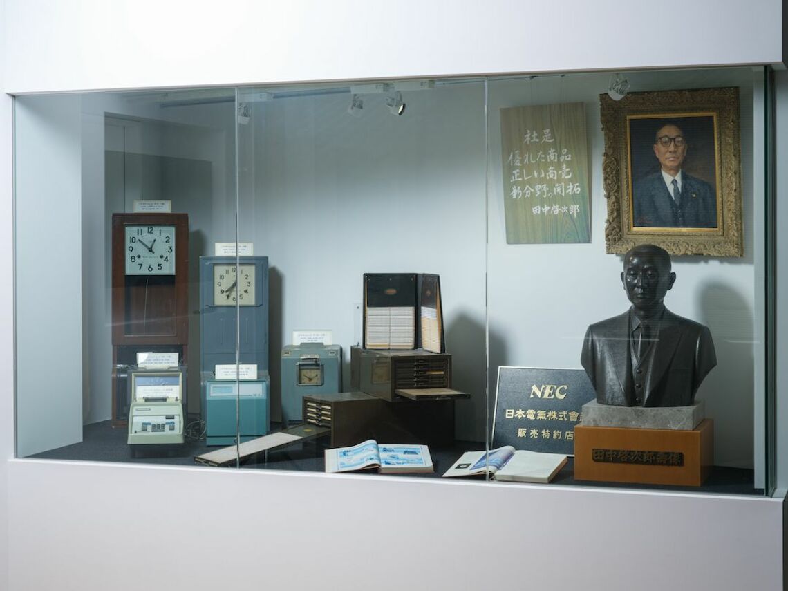 オフィスの一角に飾られた創業者田中啓次郎氏の胸像や、初期のタイムレコーダの写真
