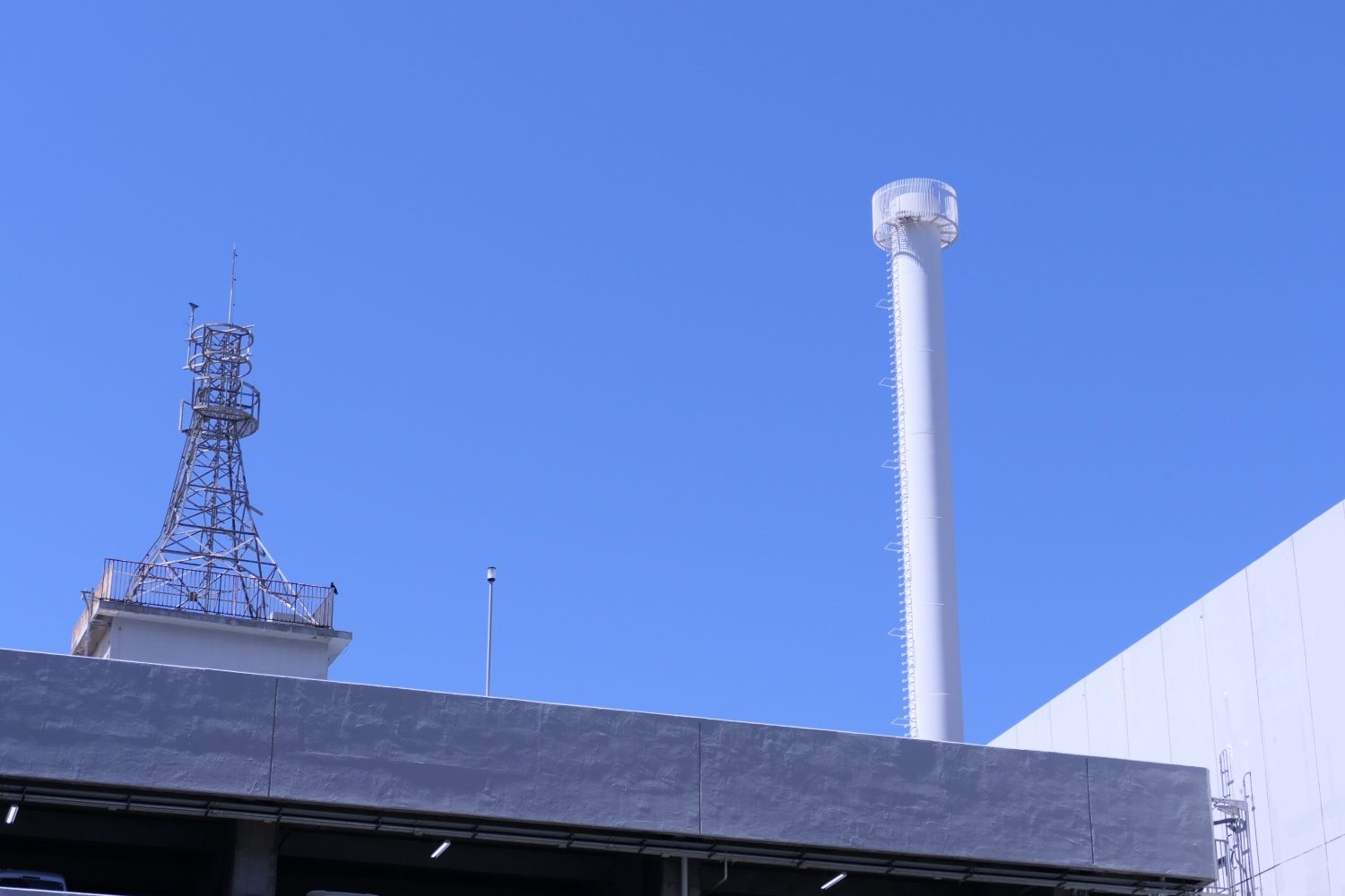 旧機械棟の煙突。京阪天満橋ビル屋上の塔も見える（記者撮影）