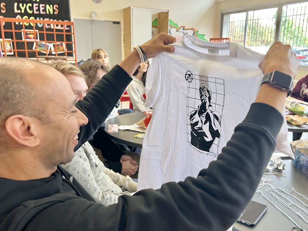 生徒から『GTO』主役グレートティーチャー・オニヅカのTシャツをもらい、喜ぶカリムさん（筆者撮影）