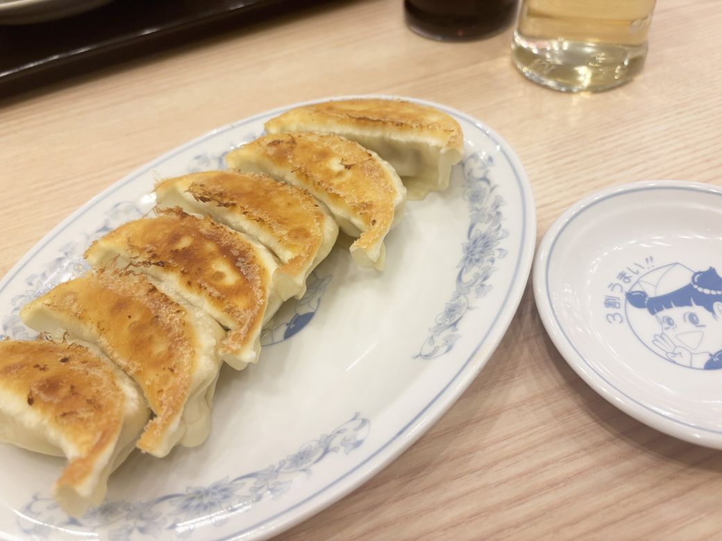 皮がパリパリでもっちり、肉本来の味を楽しめる餃子。小皿にはイメージキャラクターの「ランちゃん」が（筆者撮影）