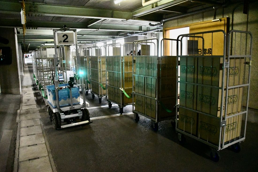 運行開始直前の訓練時の様子。荷物を載せた台車を牽引して走るAGV（記者撮影）