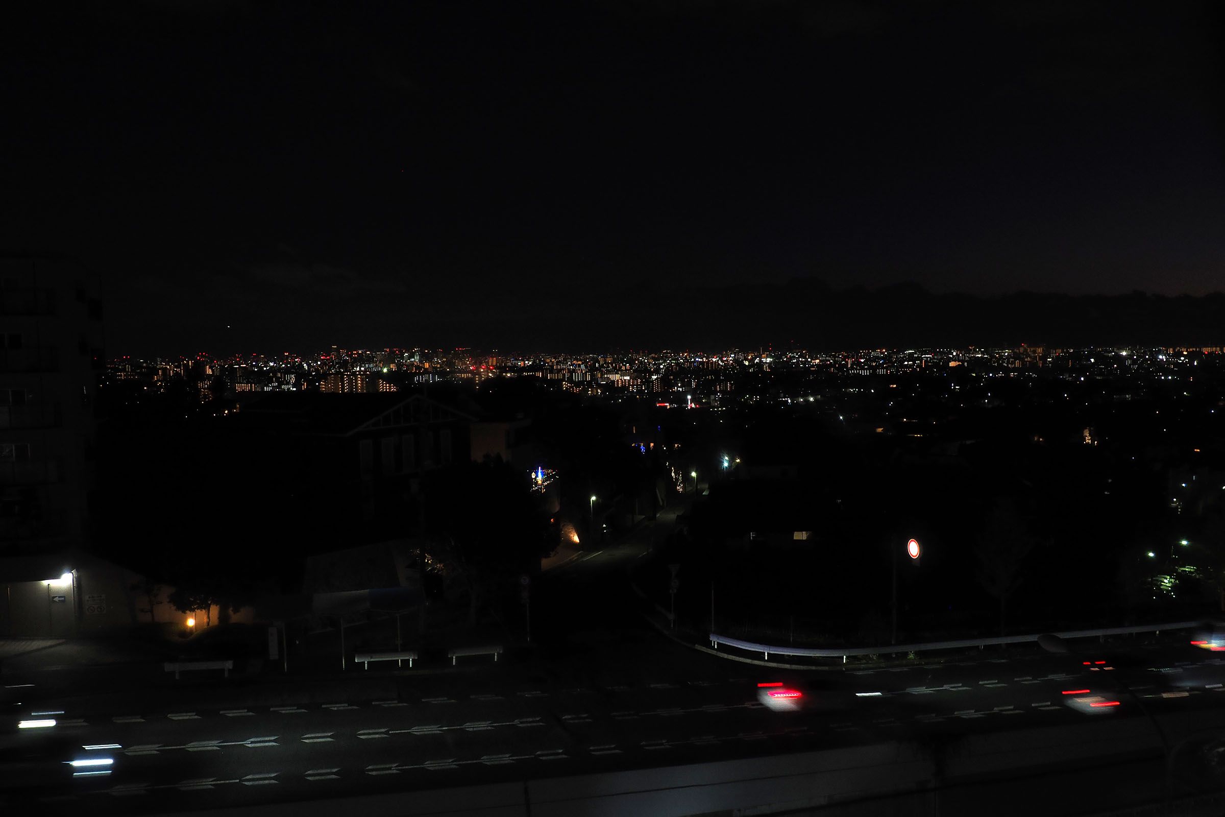 少路―千里中央間の車内から見た夜景。かなたに見えるのは大阪市街＝2023年11月（撮影：伊原薫）