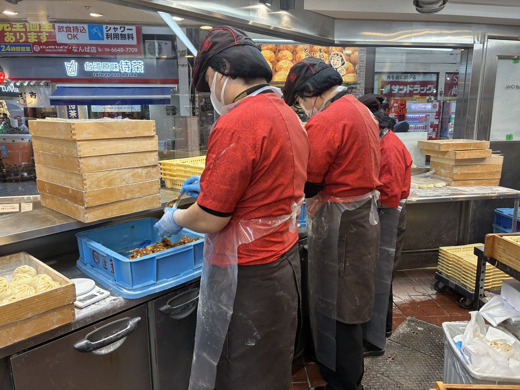 作っている人からも、ガラスの向こうに並ぶ人々が見えている（筆者撮影）