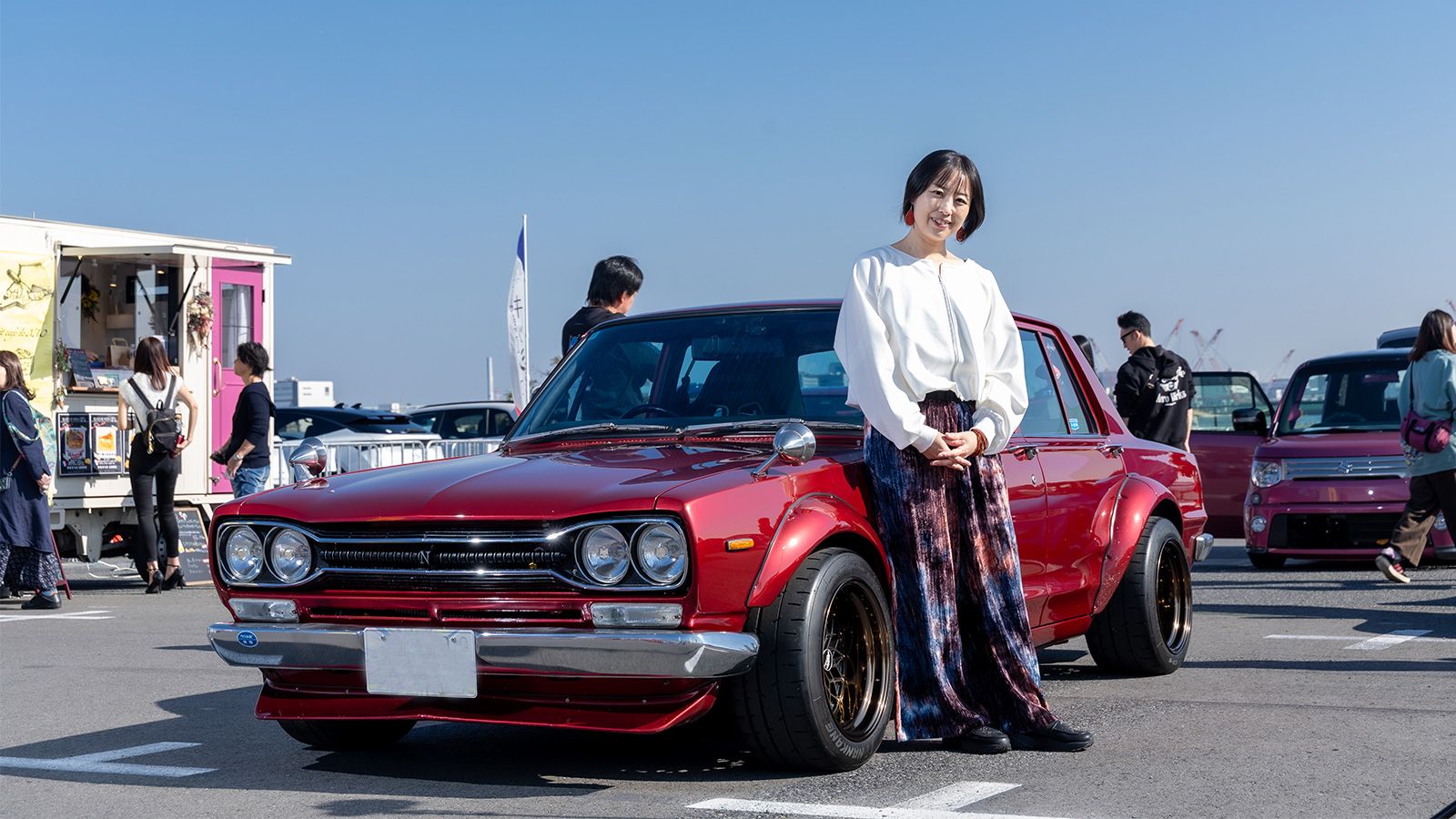 主催の峯野アグネスさん。愛車は日産の3代目スカイライン、通称ハコスカと呼ばれるクルマ（写真：三木 宏章）
