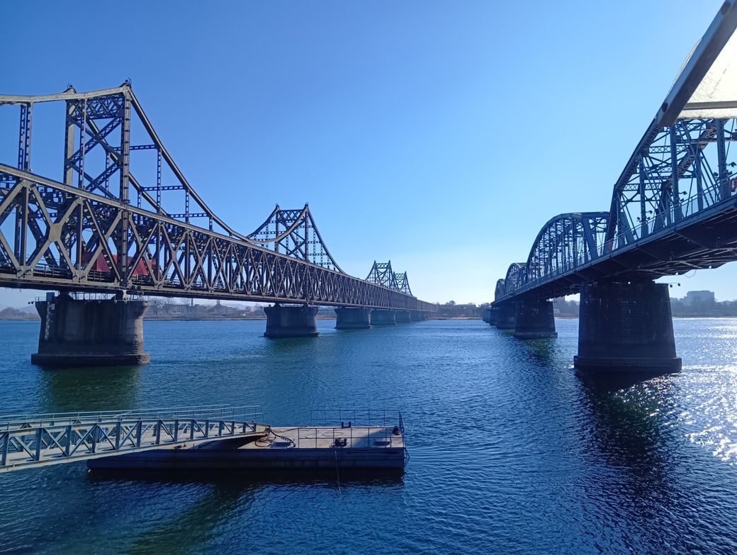 中国と北朝鮮を結んでいる現役の橋は左側。赤色のコンテナトラックが走行している姿が確認できる（筆者撮影）