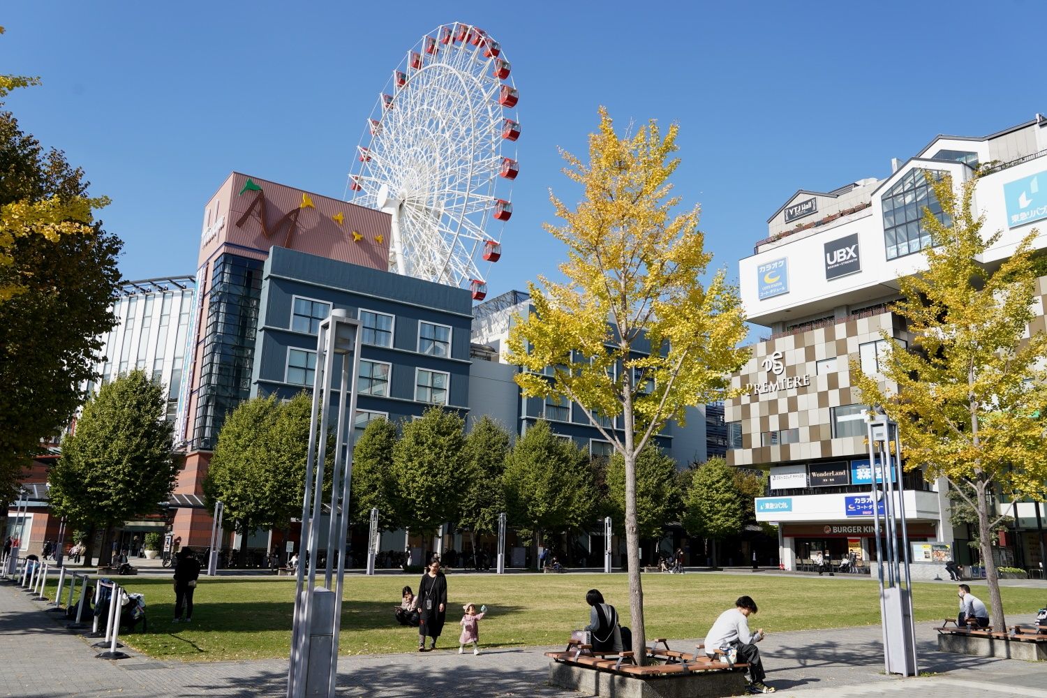 センター北駅前の芝生広場と「モザイクモール港北」（筆者撮影）