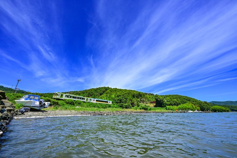 養殖が盛んに行われている万石浦（まんごくうら）をゆく石巻線。万石浦は種牡蠣の養殖が盛んで世界に輸出されており、世界中の牡蠣の8割はここ万石浦の海にルーツがあるとも言われている（筆者撮影）