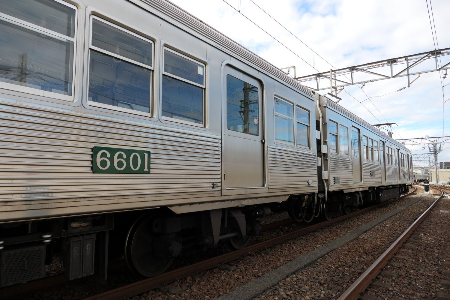 ステンレス無塗装復活車両のナンバーは緑色のプレート（記者撮影）