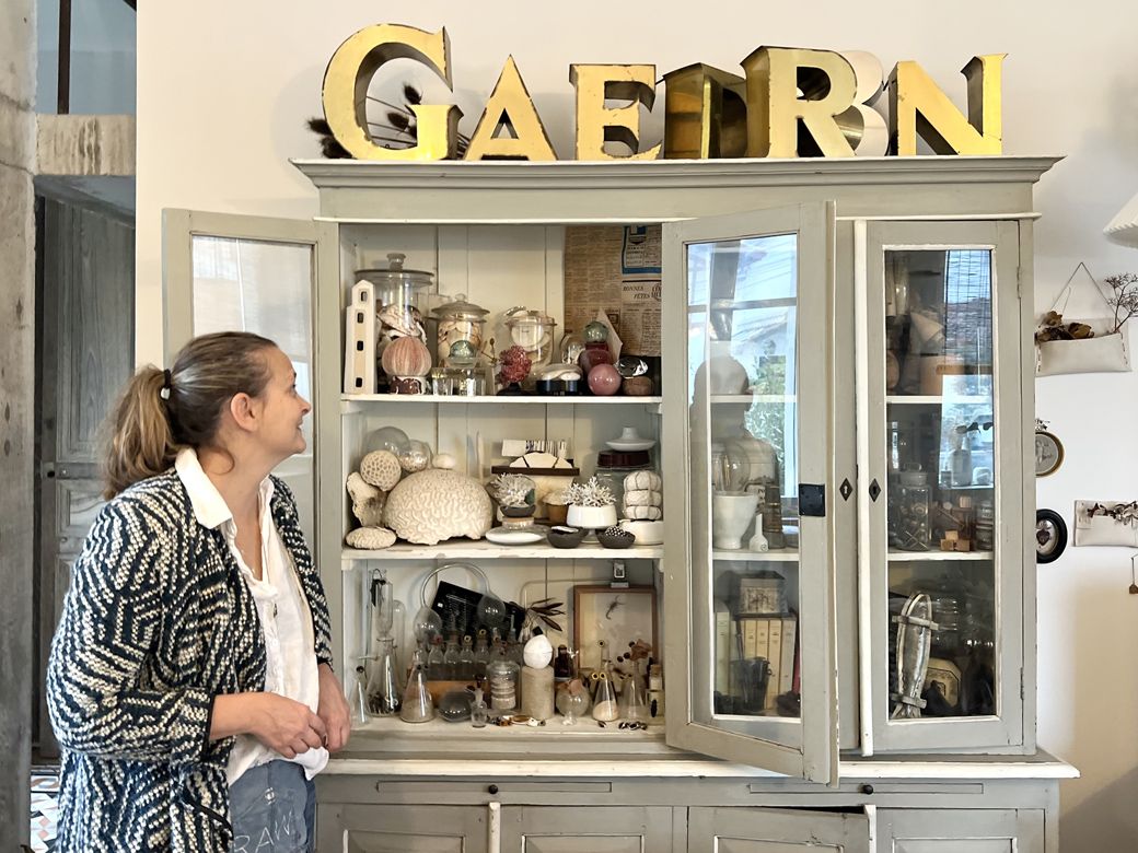 旅先で出会った宝物が詰まっている、ナデージュさんの宝箱のような棚（筆者撮影）