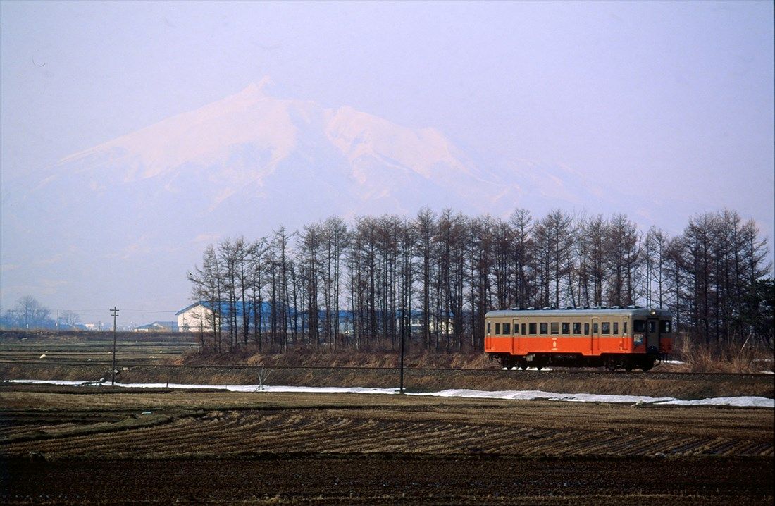 岩木山をバックに走る津軽鉄道の気動車（撮影：南正時）