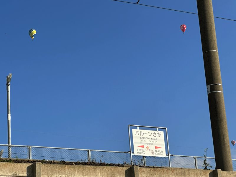 閉鎖された「バルーンさが」駅の向こうに飛ぶバルーン（筆者撮影）