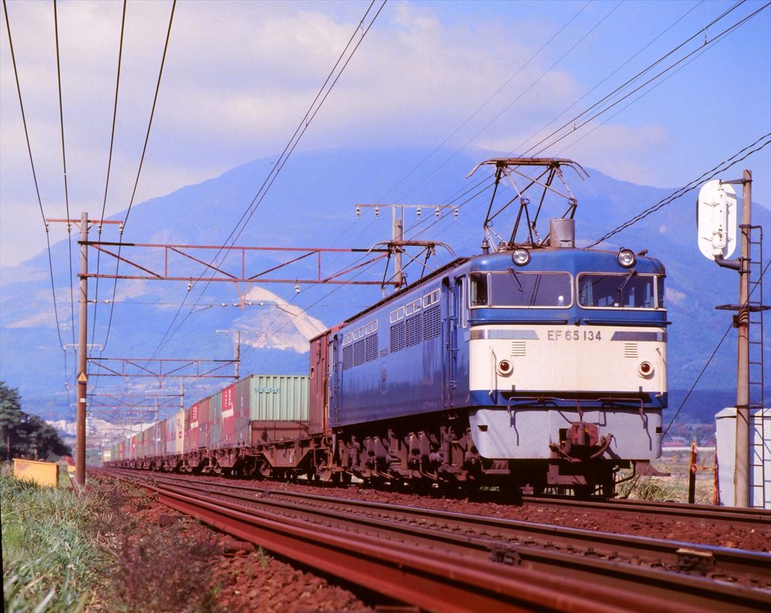 コンテナ貨物列車を牽いて近江長岡付近を快走するEF65形＝1976年（撮影：南正時）