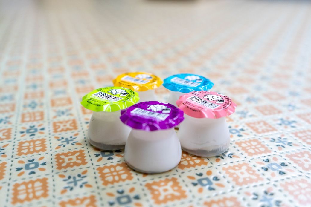 容器は、かつて牛乳店が配達していた瓶入りヨーグルトをデフォルメしたもの。フタの周囲にあるヒダ状の凹凸は、当時の瓶にかぶせられていたビニールと輪ゴムの形状を模している（写真：筆者撮影）