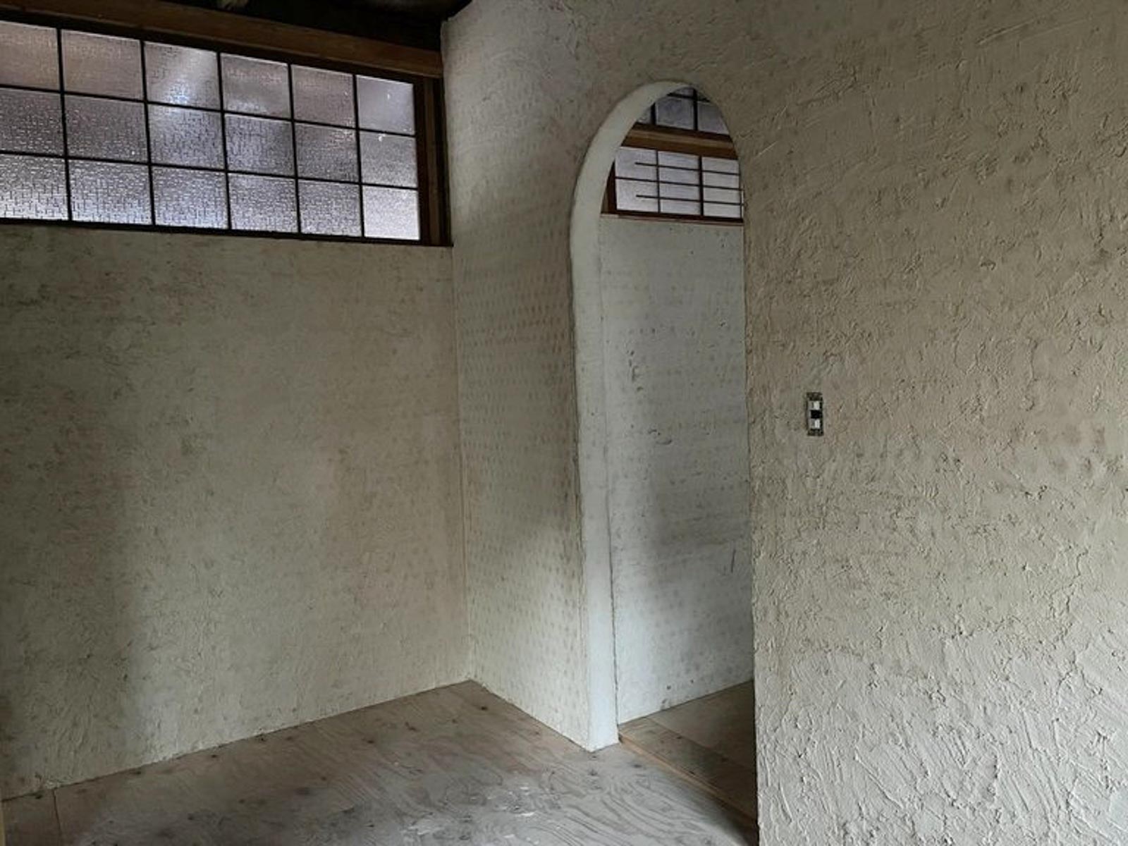 漆喰を塗り終えた後。奥の壁は廃材の凸凹が漆喰の上からでも分かる（写真提供：山脈）