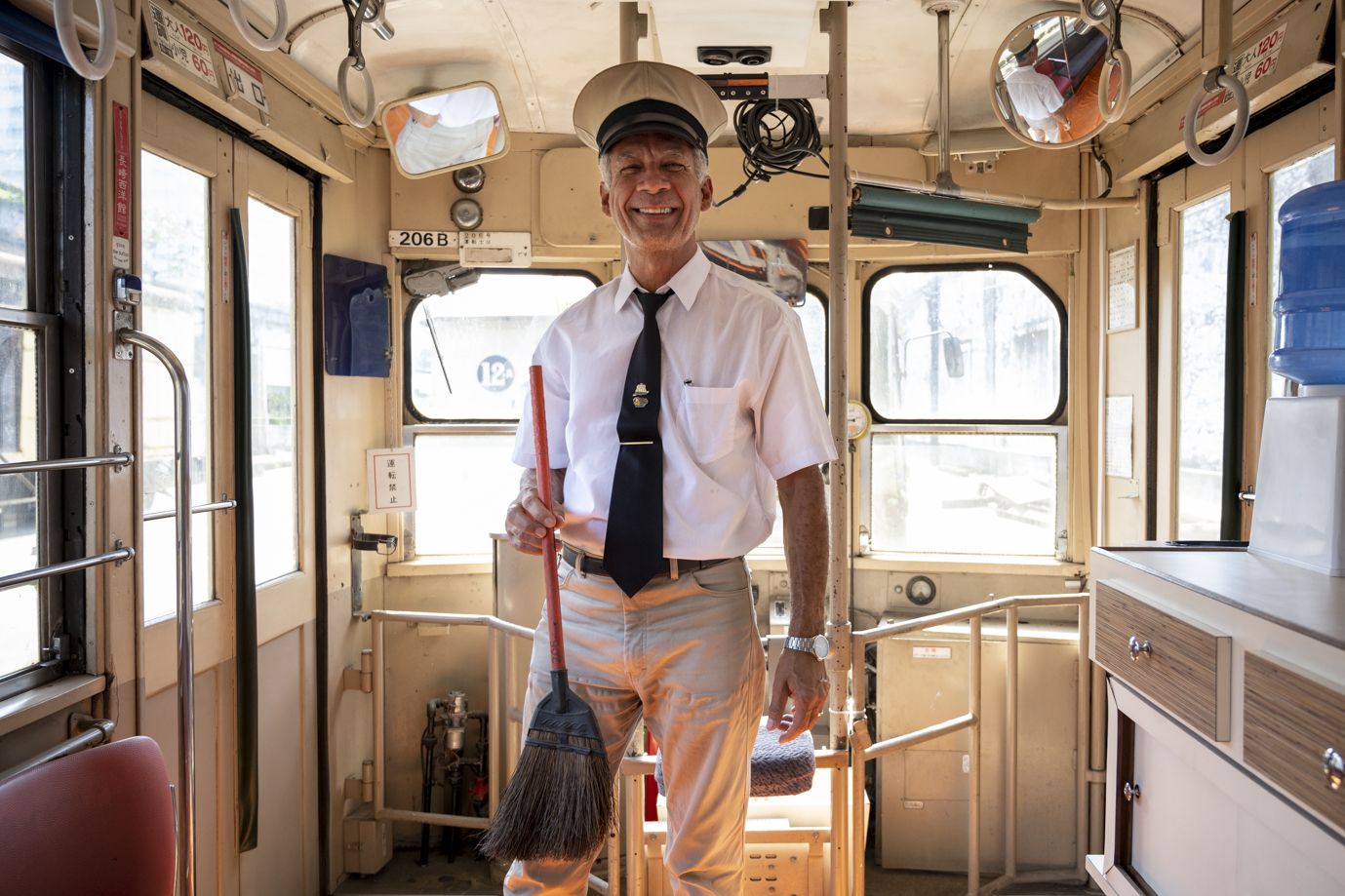 日本製ホウキを手にする制服姿のドゥアルテ氏（写真：筆者撮影） 