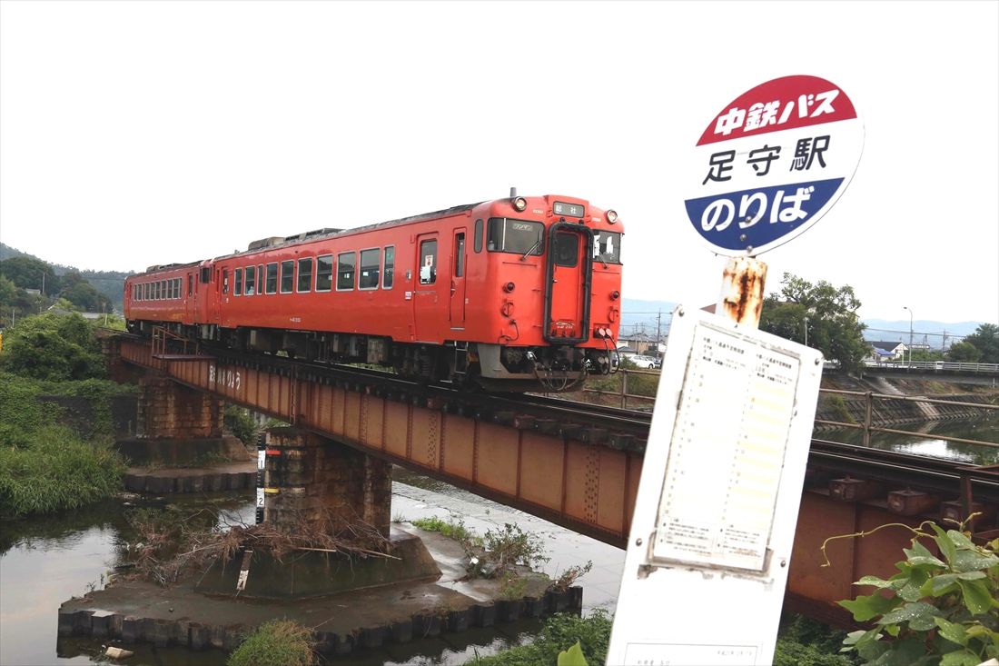 吉備線の足守駅付近、バス停の標識とタラコ色のキハ40形（撮影：南正時）