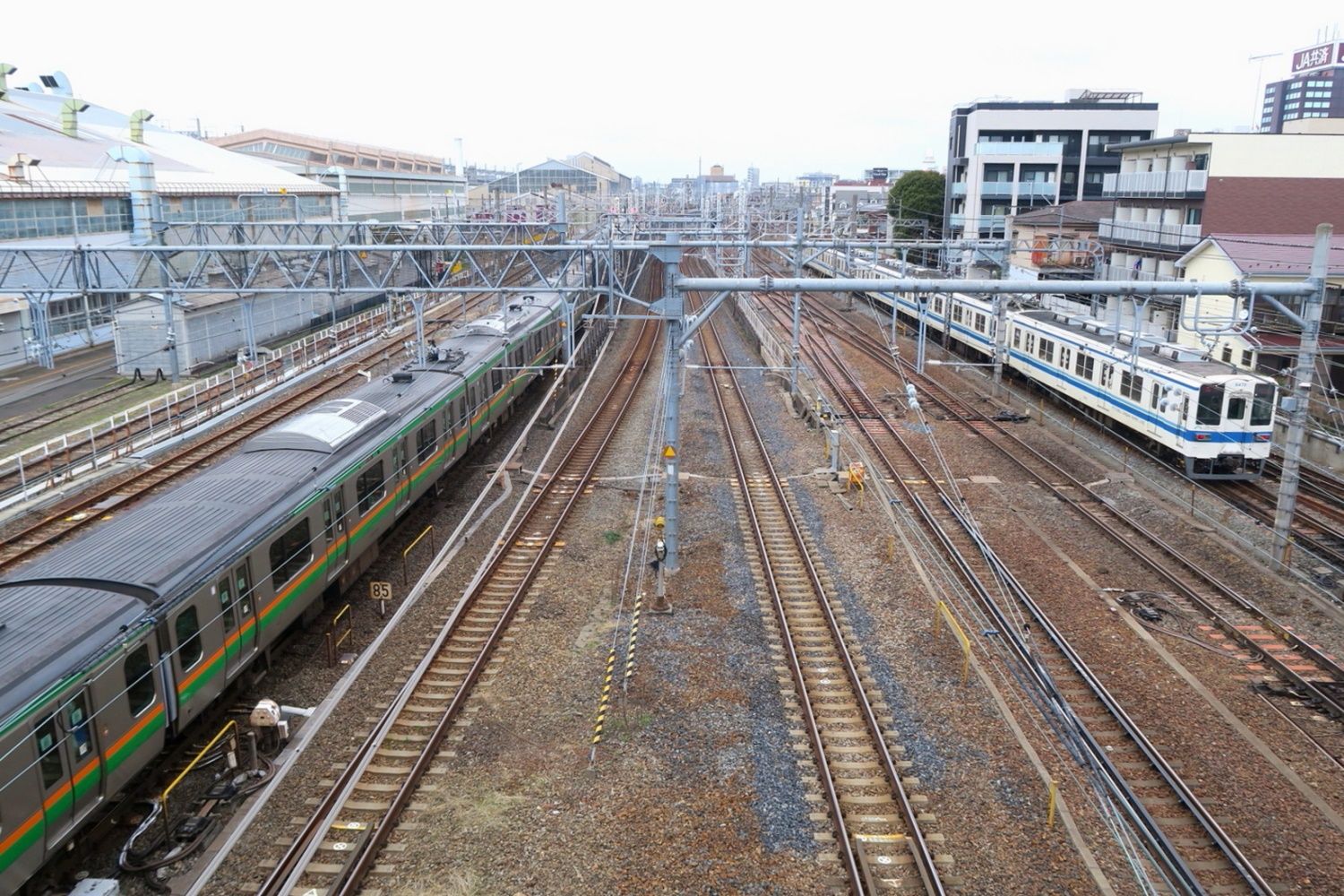 大宮総合車両センター脇を走るJR東日本と東武鉄道の電車（筆者撮影）