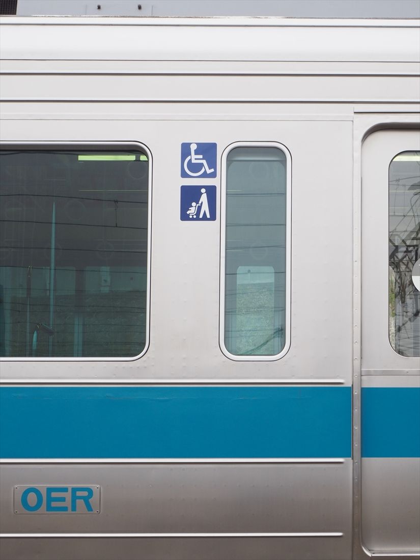 車いす・ベビーカー用スペースを示す車外のマーク（記者撮影）