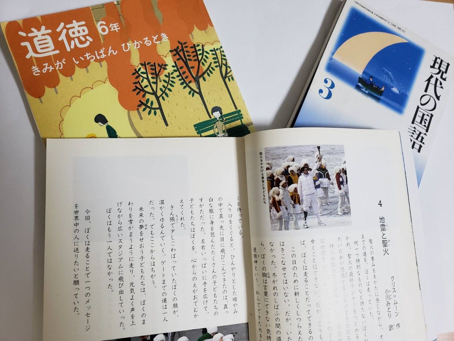 小川さんが 書いた文章が掲載された小学校5、6年生の道徳の教科書と中学校3年生の 国語の教科書。今はもう載っていないが、小学校の道徳の教科書の文章は、国語の授業で活用している（写真：小川さん提供）