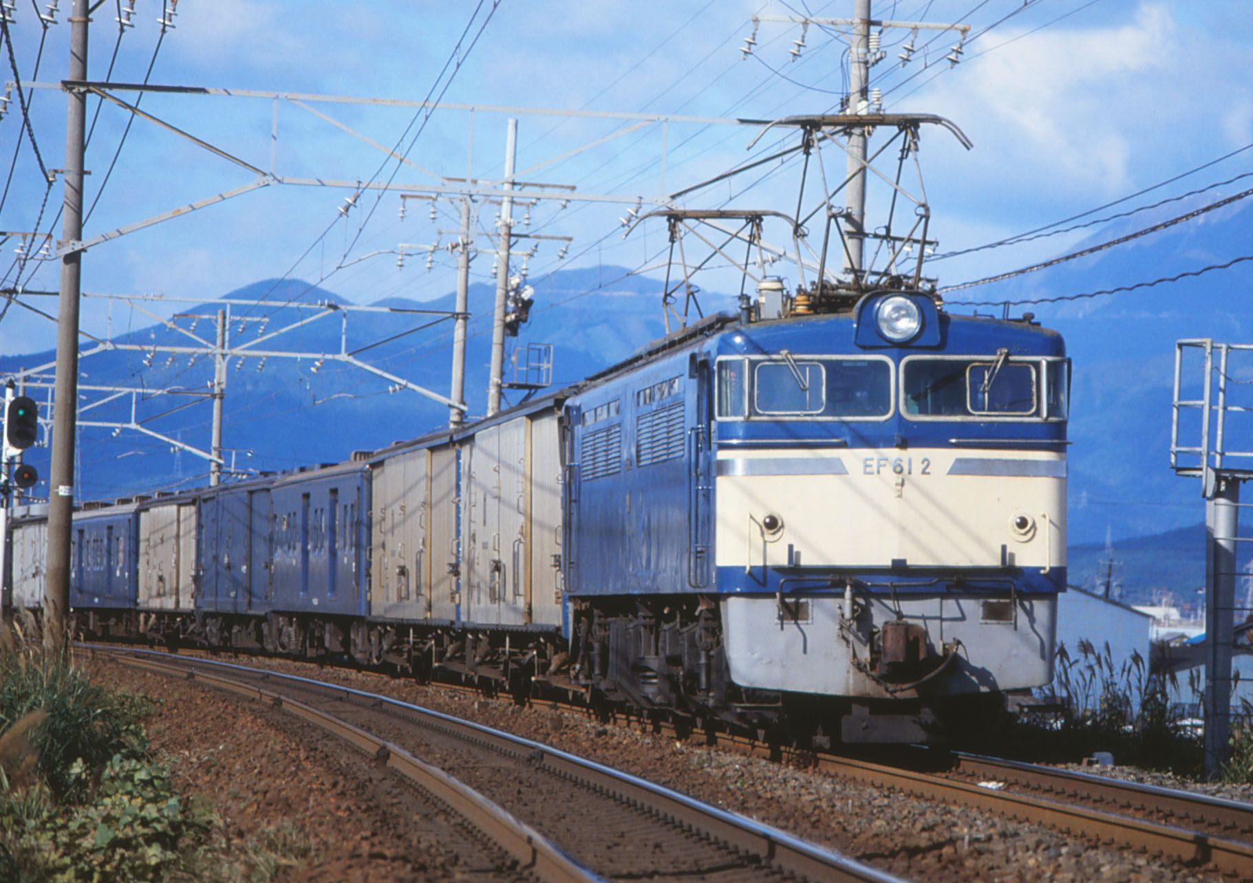 EF60形を旅客列車にも対応できるようにしたEF61形。伊吹山をバックに荷物列車の先頭に立つ姿（撮影：南正時）