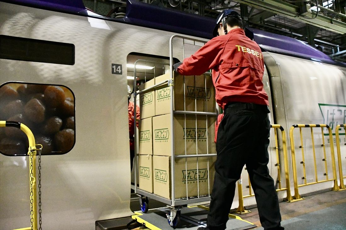 運行開始直前の訓練時の様子。車内から荷物を載せた台車を下ろすスタッフ（記者撮影）