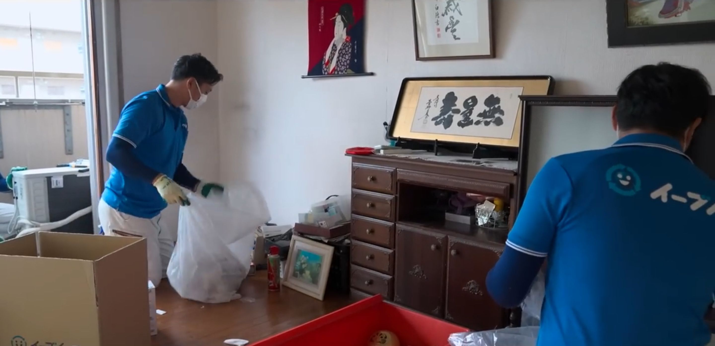 いちばんモノが多かったリビングを片付けるスタッフたち（写真：「イーブイ片付けチャンネル」より）