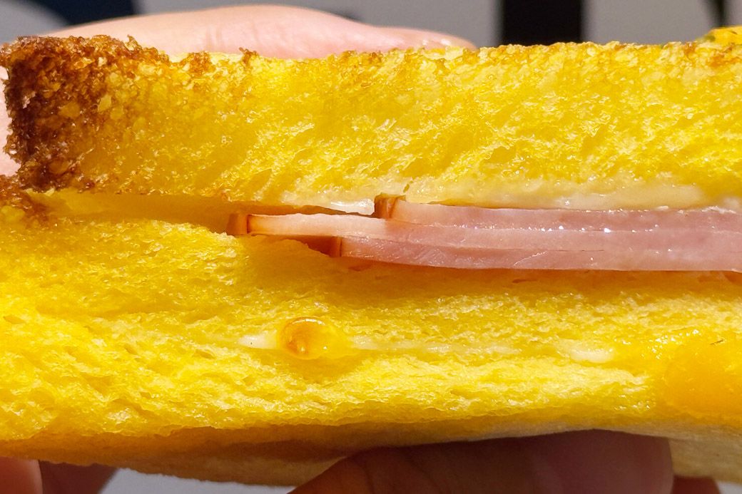 クロックムッシュには半月ハム3枚をクリーミーで酸味のある特製ベシャメルソースでサンド。三角サンドイッチを卵液にくぐらせてこんがり焼いてある（筆者撮影）