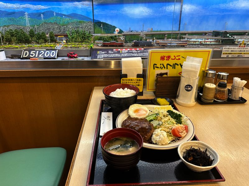 ハンバーグ定食越しの鉄道ジオラマ（筆者撮影）