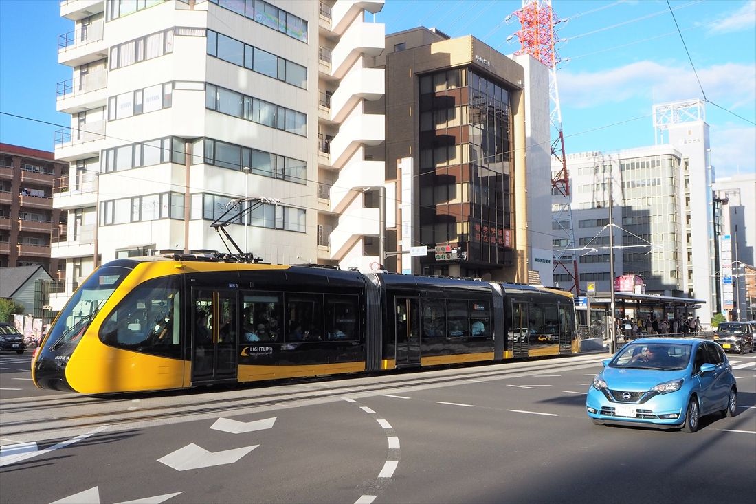 車と並走するLRT＝2023年8月26日（記者撮影）