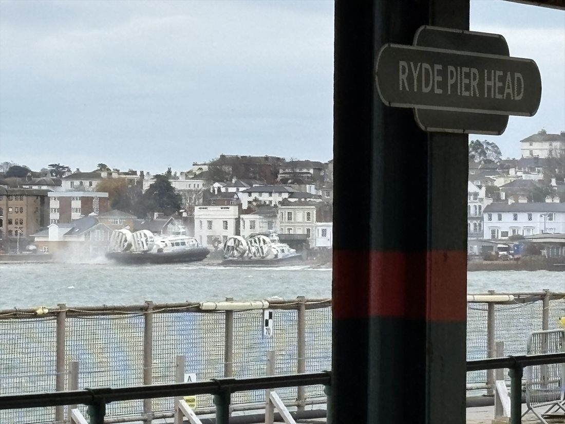 桟橋の先端から見た陸地。ライドピアヘッド駅の駅名標の奥にホーバークラフトの姿が見える（筆者撮影）