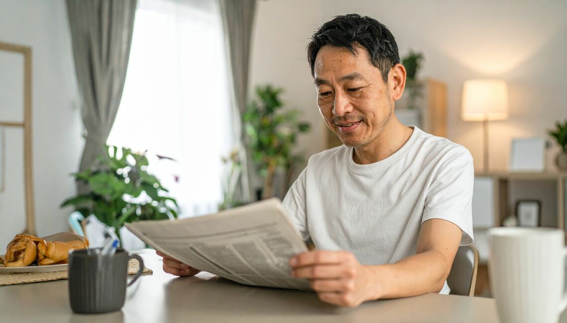 朝刊を読む男性のイメージ