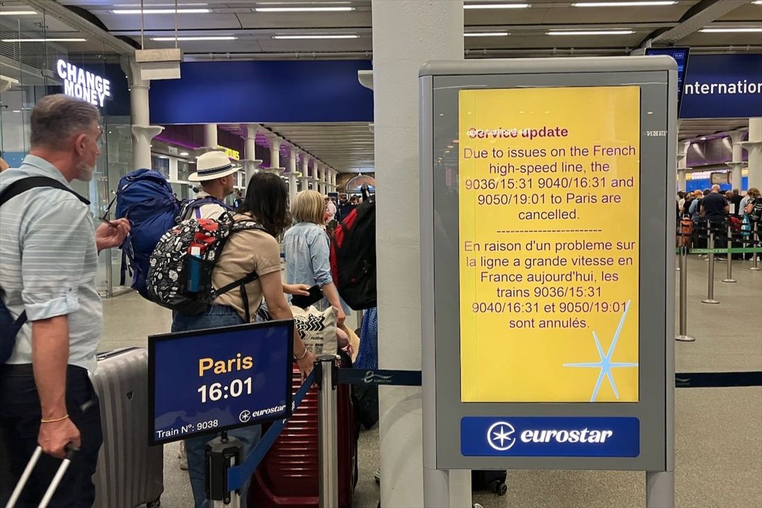 イギリスとフランス方面を結ぶ「ユーロスター」が発着するロンドン・セントパンクラス駅。運休便を告知する案内板と、数少ない列車に乗る人々の列＝7月26日（筆者撮影）