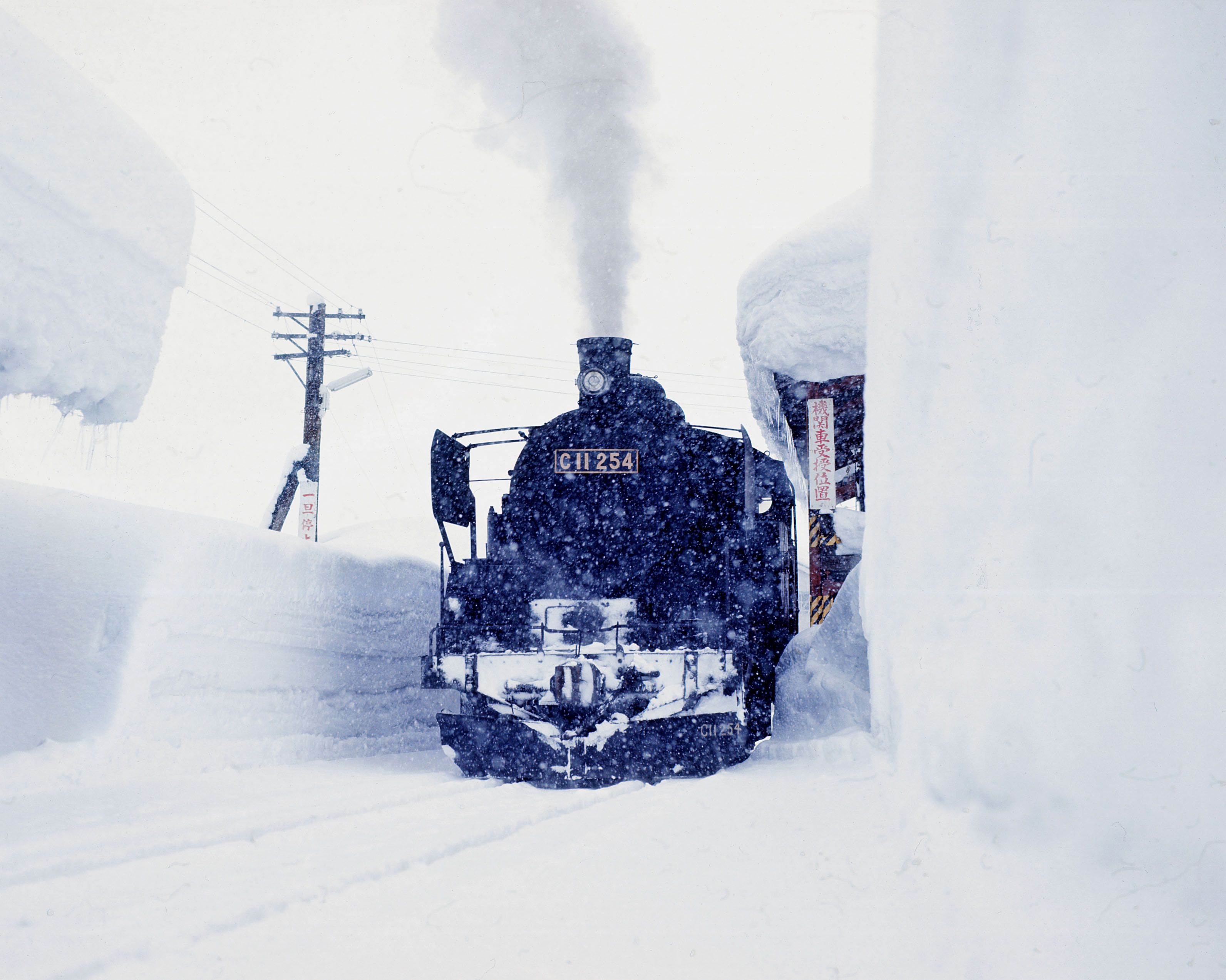 昭和49年豪雪の際の只見線。高い雪の壁に囲まれたC11形蒸気機関車が煙を噴き上げる＝1974年（撮影：南正時）